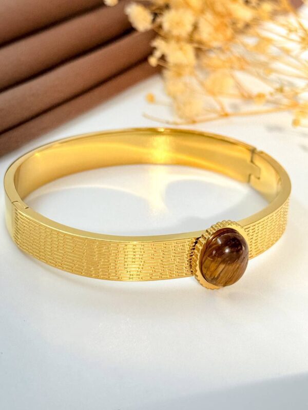 Eye twist brown gold plated bangle
